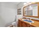 Bathroom with a rustic wood vanity, decorative sink, and neutral tile shower at 2016 E Orangewood Ave, Phoenix, AZ 85020