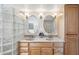 Bathroom featuring a double vanity and a glass block shower wall at 2016 E Orangewood Ave, Phoenix, AZ 85020