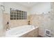 Bathroom with tiled-in tub and decorative glass block window at 2016 E Orangewood Ave, Phoenix, AZ 85020