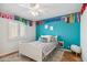 Cozy bedroom featuring a twin bed, ceiling fan, and colorful decorative accents at 2016 E Orangewood Ave, Phoenix, AZ 85020