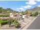 Charming home with desert landscaping, a red tile roof, and a mountainside in the background at 2016 E Orangewood Ave, Phoenix, AZ 85020