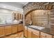 Functional kitchen with light wood cabinets, granite countertops, and a brick arch over the stovetop at 2016 E Orangewood Ave, Phoenix, AZ 85020