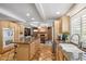 Spacious kitchen with granite countertops, wooden cabinets, a large island and a view of a brick fireplace at 2016 E Orangewood Ave, Phoenix, AZ 85020