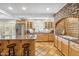 Well-equipped kitchen with stainless steel appliances, a kitchen island with barstool seating and custom brick arch at 2016 E Orangewood Ave, Phoenix, AZ 85020