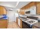 Efficient kitchen featuring wood cabinets, tile floors, and modern appliances at 2016 E Orangewood Ave, Phoenix, AZ 85020