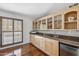 Bright kitchenette with granite countertops, wood cabinets with glass fronts, and a mini-refrigerator at 2016 E Orangewood Ave, Phoenix, AZ 85020