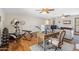 This living room area features hardwood floors, a ceiling fan, an exercise machine and an adjacent desk at 2016 E Orangewood Ave, Phoenix, AZ 85020
