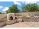 Charming outdoor fireplace with seating, a brick patio, and tasteful landscaping at 2016 E Orangewood Ave, Phoenix, AZ 85020
