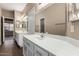 Bathroom featuring double sinks with white cabinets and a large mirror at 20670 N 41St Ave, Glendale, AZ 85308