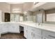Bathroom featuring double sinks with white cabinetry and a glass-enclosed shower at 20670 N 41St Ave, Glendale, AZ 85308