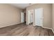 Bedroom with neutral walls and wood-look floors, with bathroom and closet access at 20670 N 41St Ave, Glendale, AZ 85308