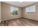 Bedroom featuring wood-look floors and two large windows for natural light at 20670 N 41St Ave, Glendale, AZ 85308