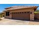 Attached garage door with decorative windows and stone trim, set against a desert backdrop at 20670 N 41St Ave, Glendale, AZ 85308