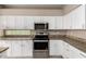 Kitchen with white cabinets, granite countertops and stainless-steel appliances at 20670 N 41St Ave, Glendale, AZ 85308