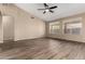 Spacious living room featuring wood-look floors, a ceiling fan, neutral walls, and bright windows with outside views at 20670 N 41St Ave, Glendale, AZ 85308