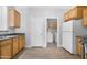 Bright kitchen with wood cabinets, black appliances, and access to a laundry room at 2565 S Signal Butte Rd # 30, Mesa, AZ 85209