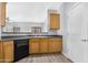 Well-lit kitchen showcasing wood cabinets, black appliances, and access to a side door at 2565 S Signal Butte Rd # 30, Mesa, AZ 85209