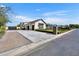 Long driveway with brick accents leading to a spacious three-car garage with black doors at 2652 E Pelican Ct, Gilbert, AZ 85297