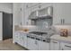 Modern kitchen features stainless steel range hood, professional gas cooktop, and gray subway tile backsplash at 2652 E Pelican Ct, Gilbert, AZ 85297