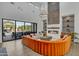 Bright living room with large windows, fireplace, and a striking orange sectional sofa at 2652 E Pelican Ct, Gilbert, AZ 85297
