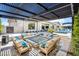 Inviting outdoor living space featuring a modern fire pit, stylish seating, and a covered patio with a view of the pool at 2652 E Pelican Ct, Gilbert, AZ 85297
