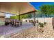Charming outdoor space with covered patio, dining area, lounge seating, and well-maintained landscaping at 27189 N 75Th Dr, Peoria, AZ 85383