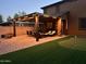 Back patio featuring a pergola, dining area, seating, mini putting green, and brick pavers at 27189 N 75Th Dr, Peoria, AZ 85383