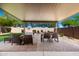 Inviting covered back patio with ample seating, a dining area, and a view of the backyard at 27189 N 75Th Dr, Peoria, AZ 85383