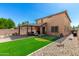 Expansive backyard featuring a covered patio,putting green, well maintained lawn, and desert landscaping at 27189 N 75Th Dr, Peoria, AZ 85383