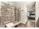 Modern bathroom with a glass enclosed shower, tiled walls, and a view into the main bedroom at 27189 N 75Th Dr, Peoria, AZ 85383