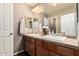 Bright bathroom with double sinks, wooden cabinets, large mirrors, and modern lighting fixtures at 27189 N 75Th Dr, Peoria, AZ 85383