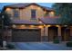 Inviting two-story home with a well-lit exterior, featuring a spacious two-car garage and covered entry at 27189 N 75Th Dr, Peoria, AZ 85383
