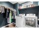 Organized laundry room with washer, dryer, storage shelves, and hanging rod for clothes at 27189 N 75Th Dr, Peoria, AZ 85383