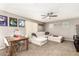 Comfortable living area with a ceiling fan, neutral-colored walls, a table, and a white sofa with an ottoman at 27189 N 75Th Dr, Peoria, AZ 85383