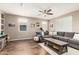 Comfortable living room with hardwood floors, a large sectional couch, and bright natural lighting at 27189 N 75Th Dr, Peoria, AZ 85383