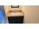 Half bathroom featuring a small sink with dark wood cabinets and neutral colored tile at 2831 E Waltann Ln # 1, Phoenix, AZ 85032