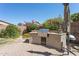 Backyard outdoor kitchen with stainless grill, bar space, desert landscaping, and shade umbrella at 29839 N Little Leaf Dr, San Tan Valley, AZ 85143