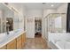 Large bathroom offers double sinks, walk-in closet, bathtub, and a glass-enclosed shower at 29839 N Little Leaf Dr, San Tan Valley, AZ 85143
