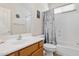 Well-lit bathroom featuring a single sink, white cabinets, and tub with seashell-themed shower curtain at 29839 N Little Leaf Dr, San Tan Valley, AZ 85143