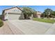 Charming single-story home with a well-manicured lawn, mature tree, and a spacious driveway at 29839 N Little Leaf Dr, San Tan Valley, AZ 85143