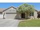 Charming single-story home with a well-manicured lawn and a beautiful, flowering tree in the front yard at 29839 N Little Leaf Dr, San Tan Valley, AZ 85143
