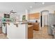 Open-concept kitchen featuring a breakfast bar, stainless steel appliances, and seamless transition to living area at 29839 N Little Leaf Dr, San Tan Valley, AZ 85143