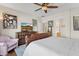 Bright main bedroom features a ceiling fan, art, and a cozy sitting area with an adjacent bathroom at 29839 N Little Leaf Dr, San Tan Valley, AZ 85143