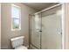 Bathroom featuring toilet, glass shower door, and a window allowing natural light at 3301 S Goldfield Rd # 1048, Apache Junction, AZ 85119