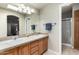 Bathroom features double sinks, a large mirror, and wood cabinets at 3301 S Goldfield Rd # 1048, Apache Junction, AZ 85119