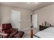 Bedroom with a carpeted floor, adjoining door, comfortable chair, and neutral-colored walls at 3301 S Goldfield Rd # 1048, Apache Junction, AZ 85119