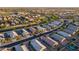 A high aerial view showing the roof and surrounding community with lush green spaces, and easy access to main roads at 36033 W Catalonia Dr, Maricopa, AZ 85138
