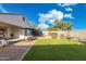 View of a backyard with artificial turf, a playground, and a seating area at 36033 W Catalonia Dr, Maricopa, AZ 85138