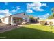 Wide angle shot of a backyard with a patio, dining area, and artificial turf at 36033 W Catalonia Dr, Maricopa, AZ 85138