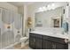 Modern bathroom with a spacious vanity, decorative mirror, and a stylish shower curtain at 36033 W Catalonia Dr, Maricopa, AZ 85138